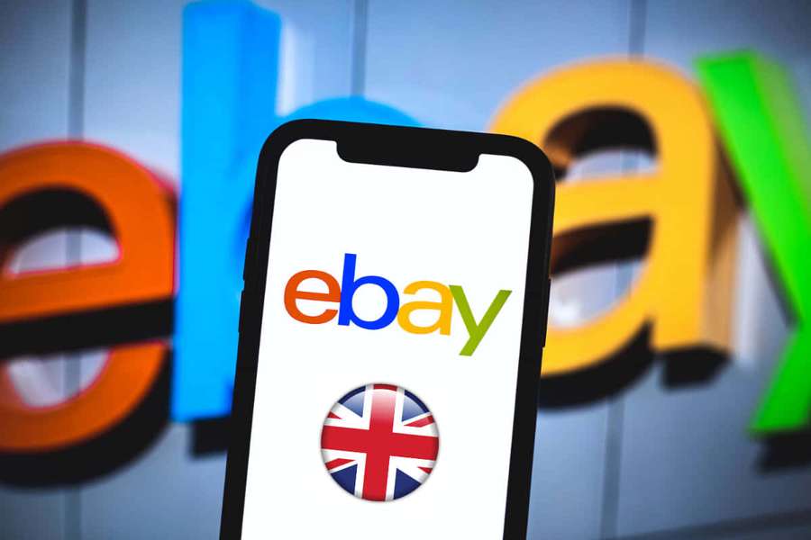Smartphone showing eBay app with UK flag icon in front of blurred eBay logo. — eBay UK Wallpaper