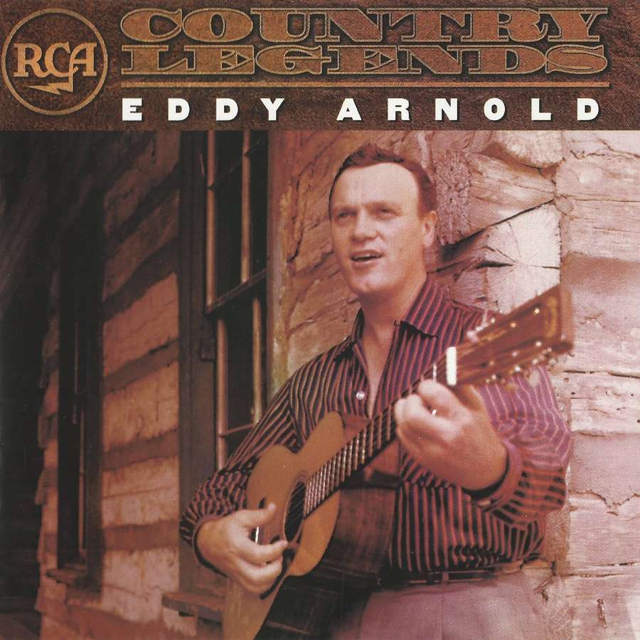 Eddy Arnold spielt Gitarre vor einer Blockhütte mit warmer Beleuchtung. — Eddie Arnold Wallpaper