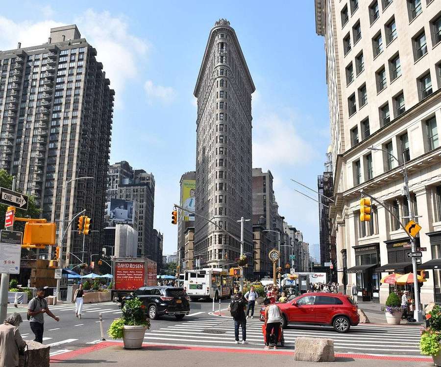 Edifício Flatiron em Nova York com pedestres e trânsito em um dia ensolarado. — Edifício Flatiron Papéis de Parede