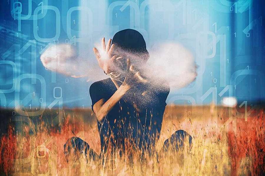 Person kneeling in grass with digital binary code swirling around them. — Effective Wallpaper