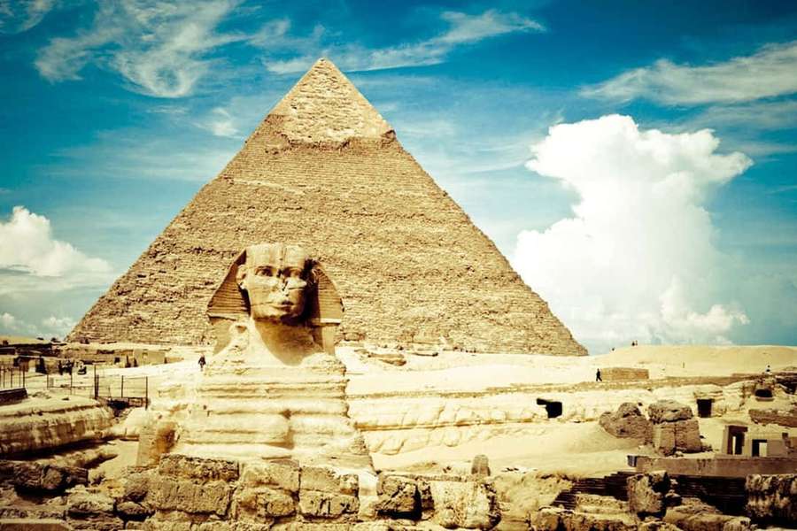 Sphinx and pyramid in desert under blue sky with clouds — Egypt Background
