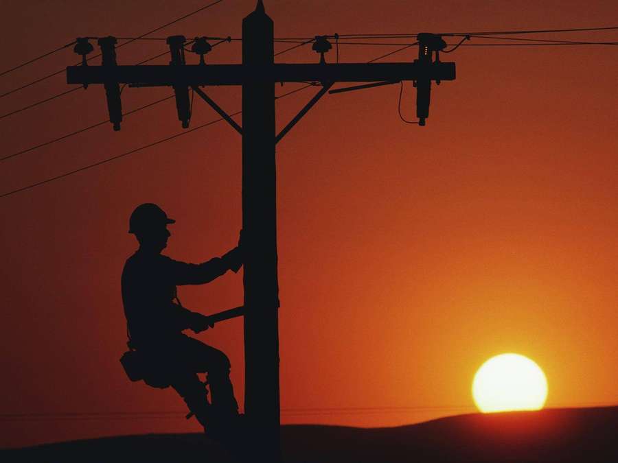 Lineman climbing utility pole at sunset — Electrician Wallpaper