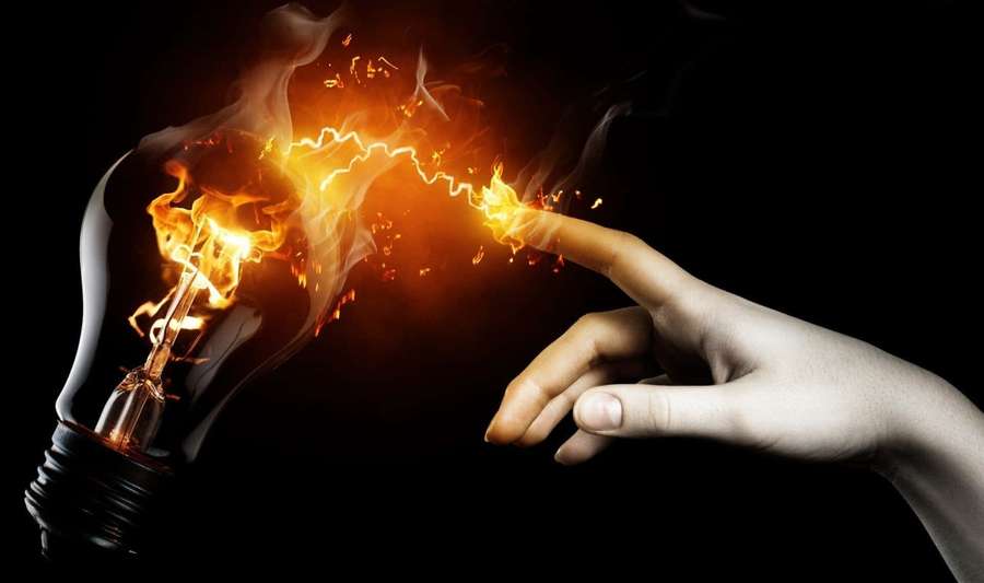 Hand touching a burning lightbulb with electric sparks flying. — Electricity Background