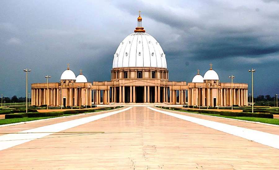 Große Kathedrale mit weißen Kuppeln unter stürmischem Himmel mit langem gefliesten Weg — Elfenbeinküste Wallpaper