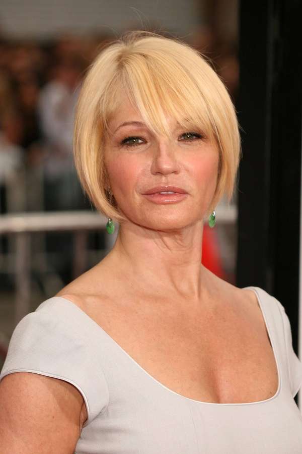 Mulher com cabelo loiro curto e brincos verdes em um vestido cinza claro. — Ellen Barkin Papéis de Parede