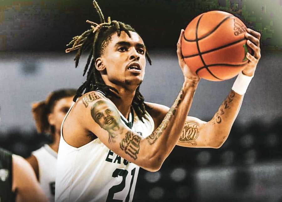 Basketball player in white jersey number 21 preparing to shoot with tattoos visible. — Emoni Bates Wallpaper