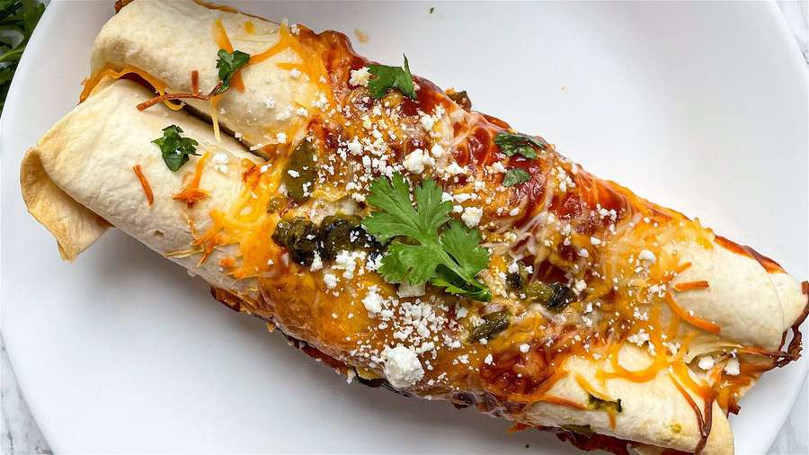 Zwei käsige Enchiladas mit Koriander auf einem weißen Teller. — Enchiladas Bilder