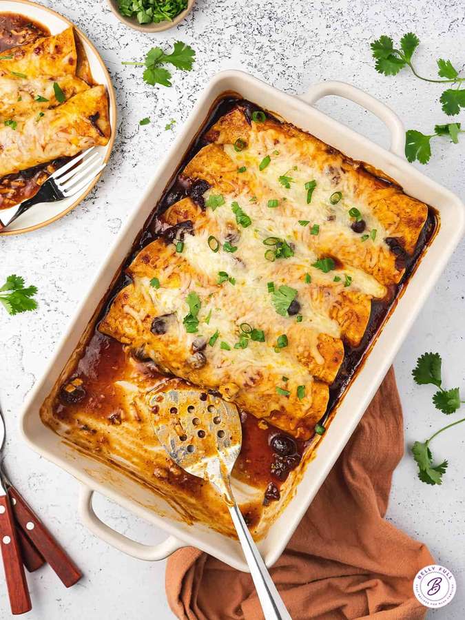 Gebackene Käse-Enchiladas mit Koriander und schwarzen Bohnen in einer weißen Form. — Enchiladas Wallpaper