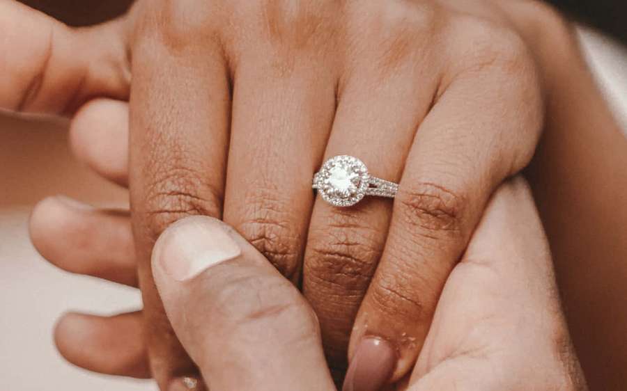 Two hands clasped together showing an engagement ring on the ring finger. — Engagement Wallpaper