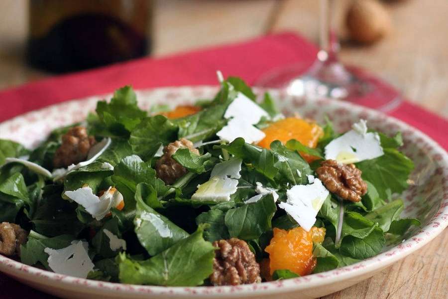 Ensalada fresca de rúcula con nueces, gajos de naranja y queso en un plato estampado. — Ensalada Fondos de pantalla