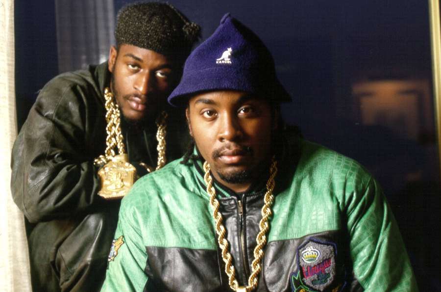 Two men in 90s hip hop gear with gold chains and beanies posing in a studio. — Eric B And Rakim Wallpaper