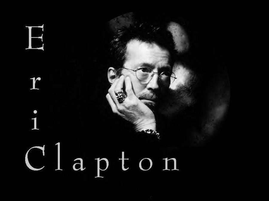Eric Clapton in a black and white portrait with glasses and hand on chin. — Eric Clapton Background