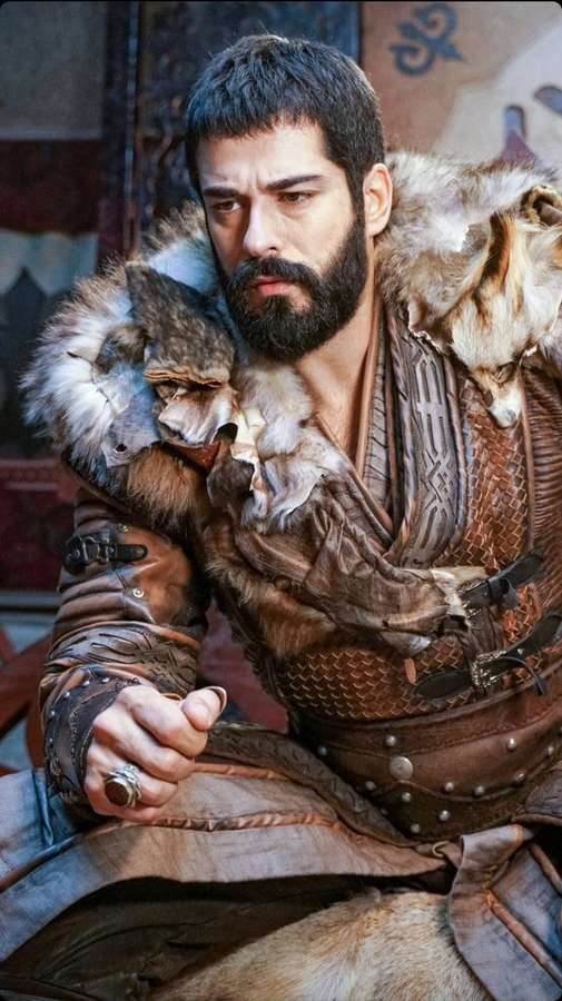 Bearded warrior in fur-lined armor with two wolves on shoulders holding dagger. — Ertugrul Wallpaper