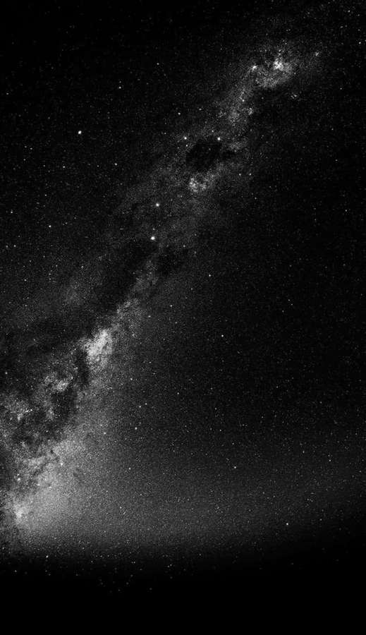 Vía Láctea brillando contra un cielo nocturno estrellado en blanco y negro. — Espacio oscuro Fondos de pantalla