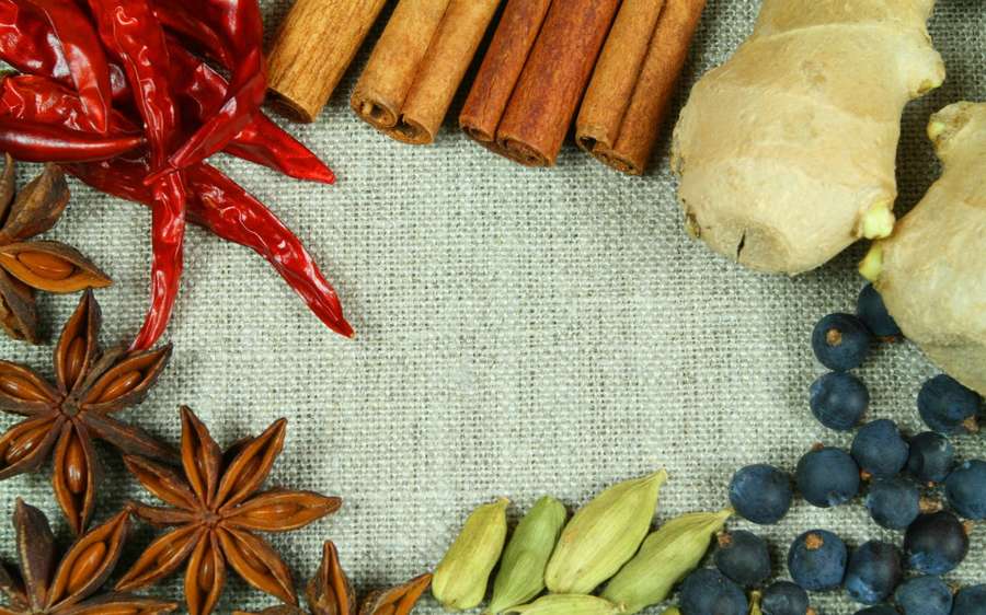 Arreglo de especias y hierbas secas sobre tela texturizada para uso culinario. — Especias Fondos de pantalla