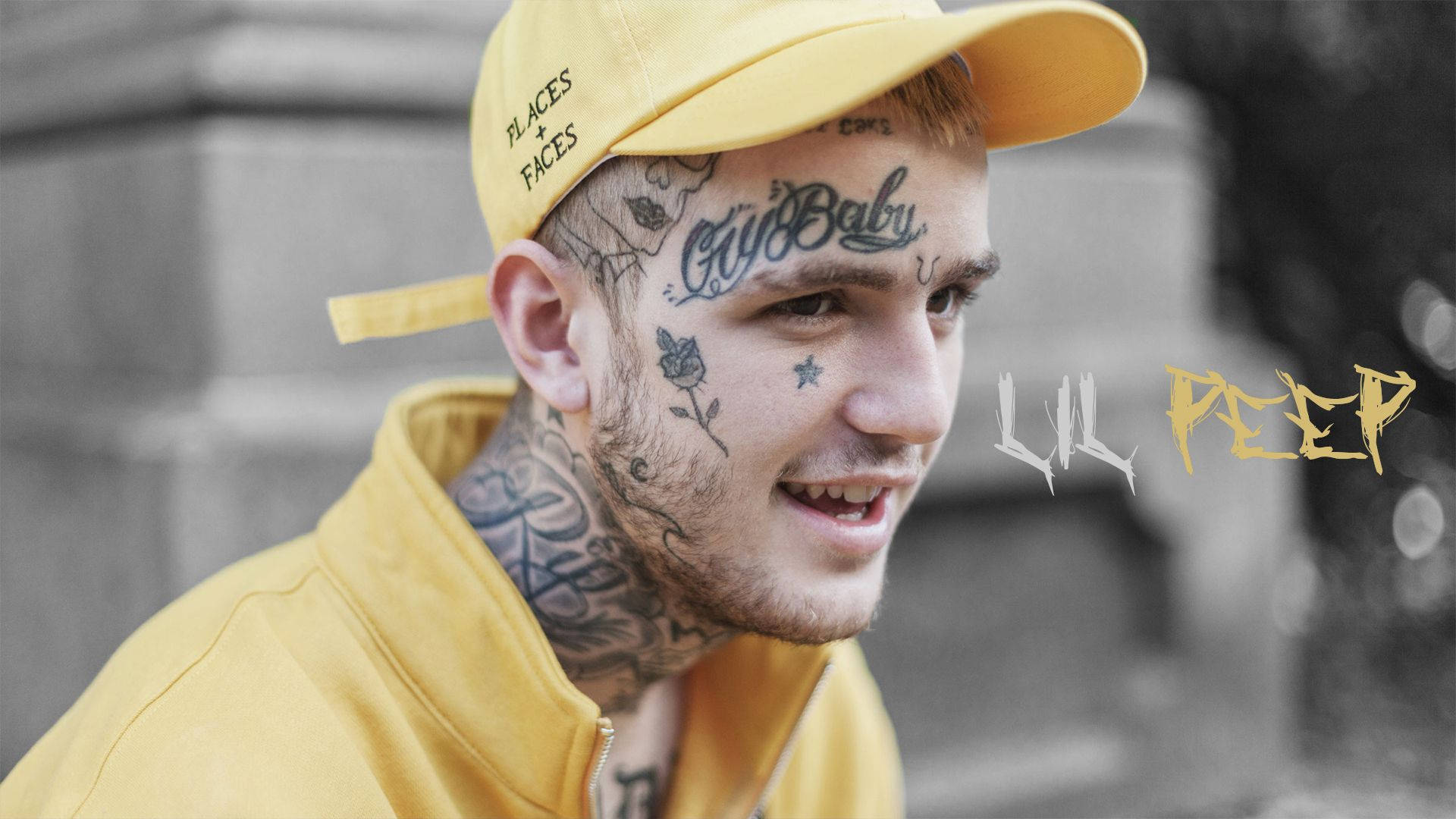 Jovem com tatuagens e boné amarelo sorrindo em ambiente urbano — Espiar Papéis de Parede