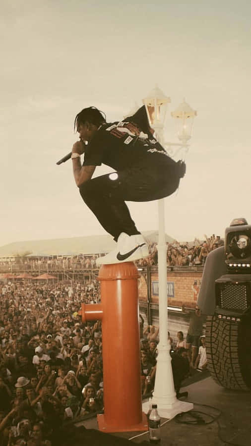 Rapper se apresentando em um hidrante em um show ao ar livre lotado. — Estética de Travis Scott Papéis de Parede