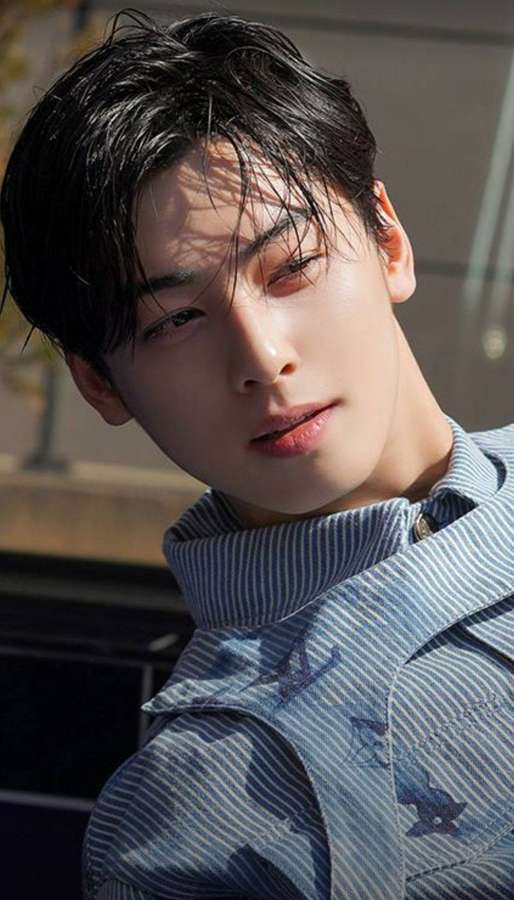 Young man in striped shirt looking at camera in bright sunlight — Eunwoo Background