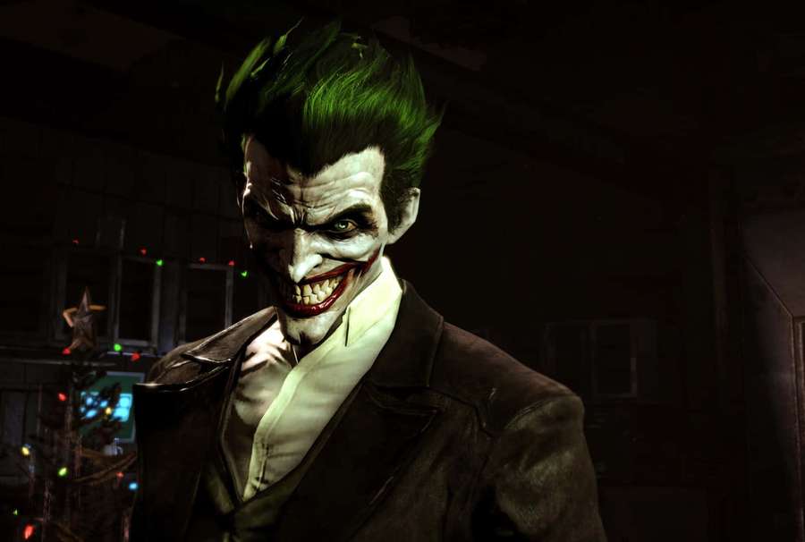 Joker in dark room with lit Christmas tree behind him. — Evil Joker Wallpaper