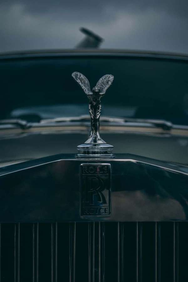 Rolls-Royce hood ornament under cloudy sky — Expensive Wallpaper