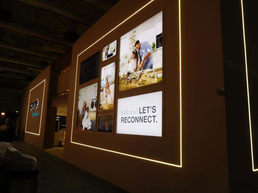 Pared con fotos familiares enmarcadas iluminadas y un letrero 'Let's Reconnect'. — Exposición Fondos de pantalla