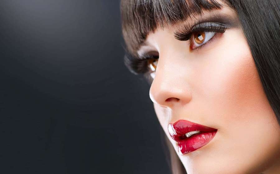 Woman with red lips and dramatic eyelashes in studio portrait. — Face Background