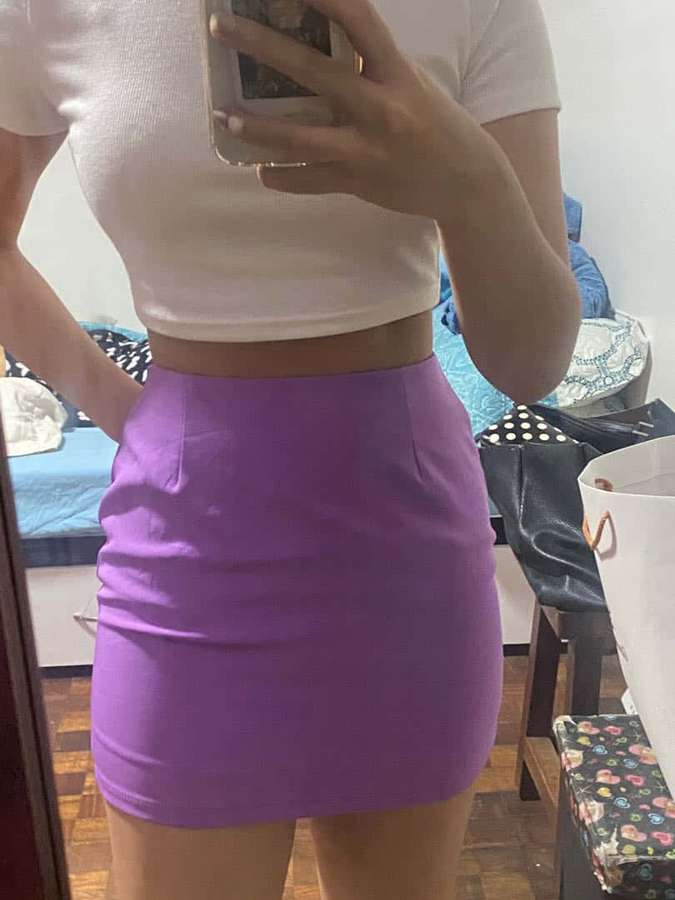 Persona con crop top blanco y falda morada tomándose un selfie en el espejo en el dormitorio. — Falda morada Fondos de pantalla