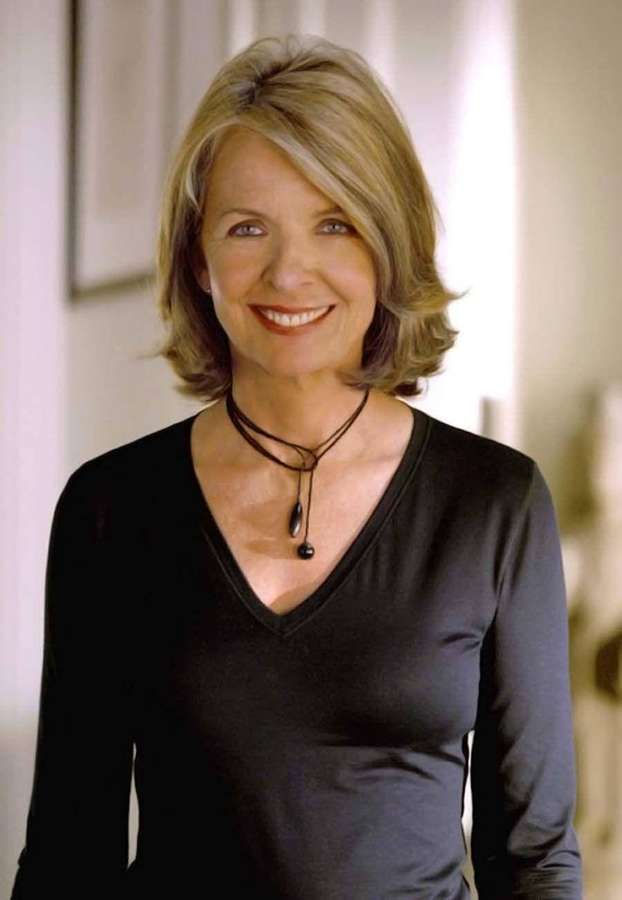 Uma mulher loira sorridente em uma blusa preta usando um colar de contas preto. — Famoso Papéis de Parede