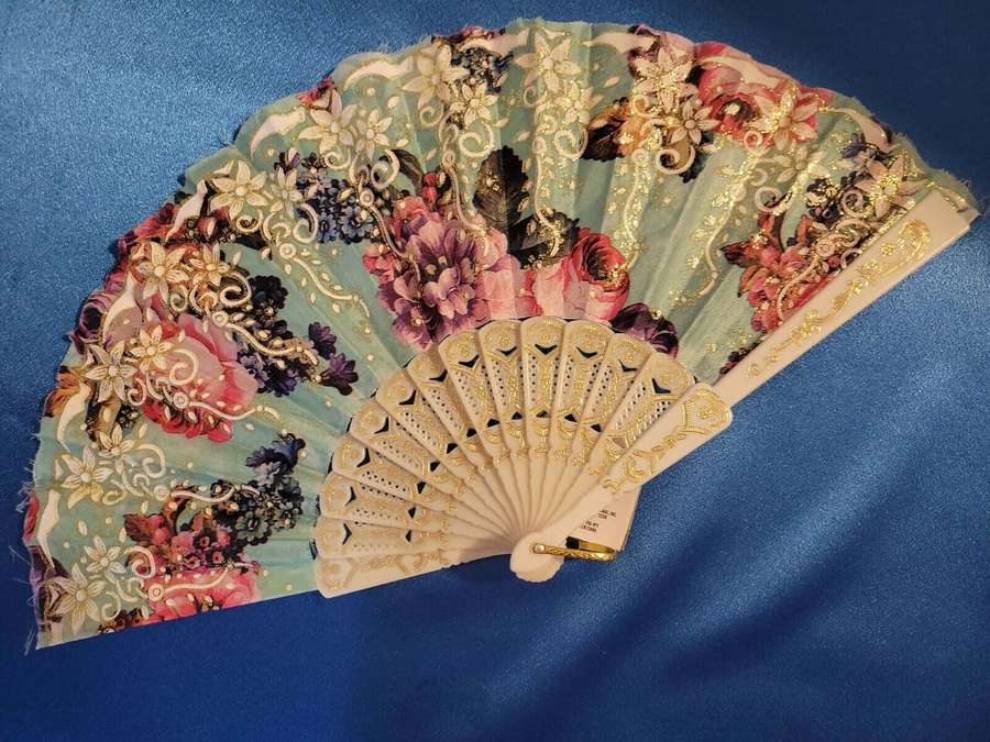 En intrikat broderad handfläkt med gulddetaljer på ett blått tyg. — Fan Bakgrundsbilder