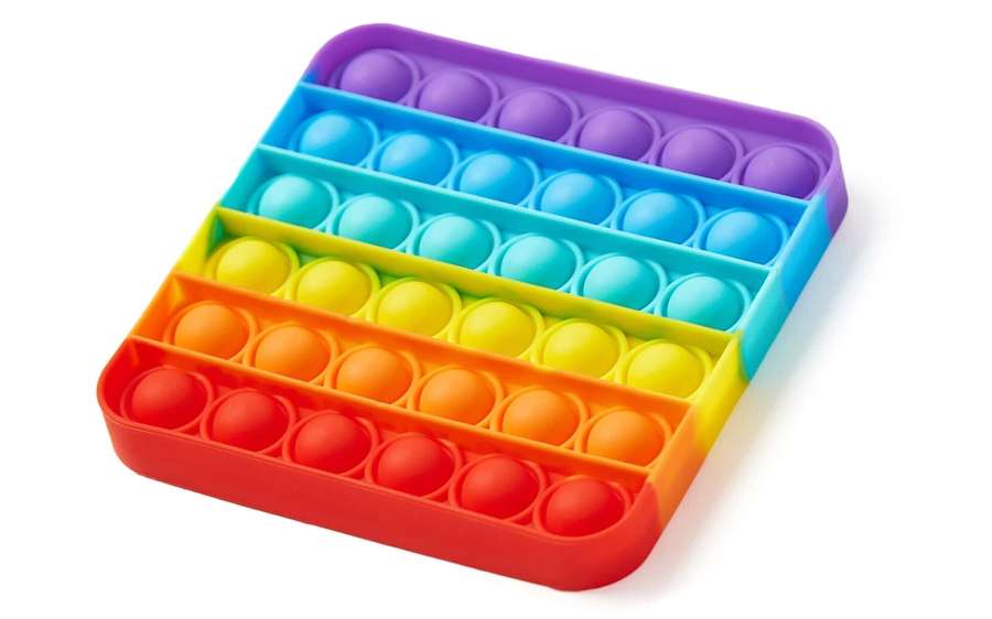 A rainbow-colored pop-it fidget toy with silicone bubbles for stress relief. — Fidget Background