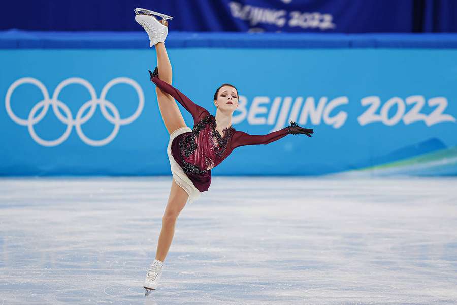 Figure skater performing a high leg extension at Beijing 2022 Winter Olympics. — Figure skating Background