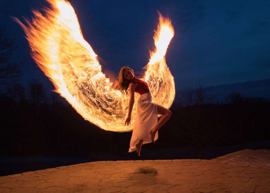 A dancer with fiery wings leaps in the twilight. — Fire Wings Wallpaper