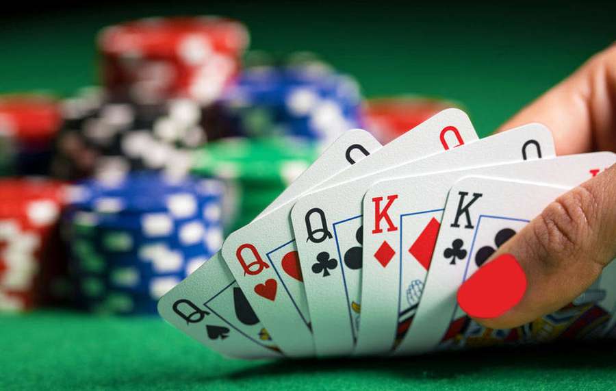 Hand holding royal flush poker cards with stacks of casino chips on green felt. — Five-card Draw Wallpaper