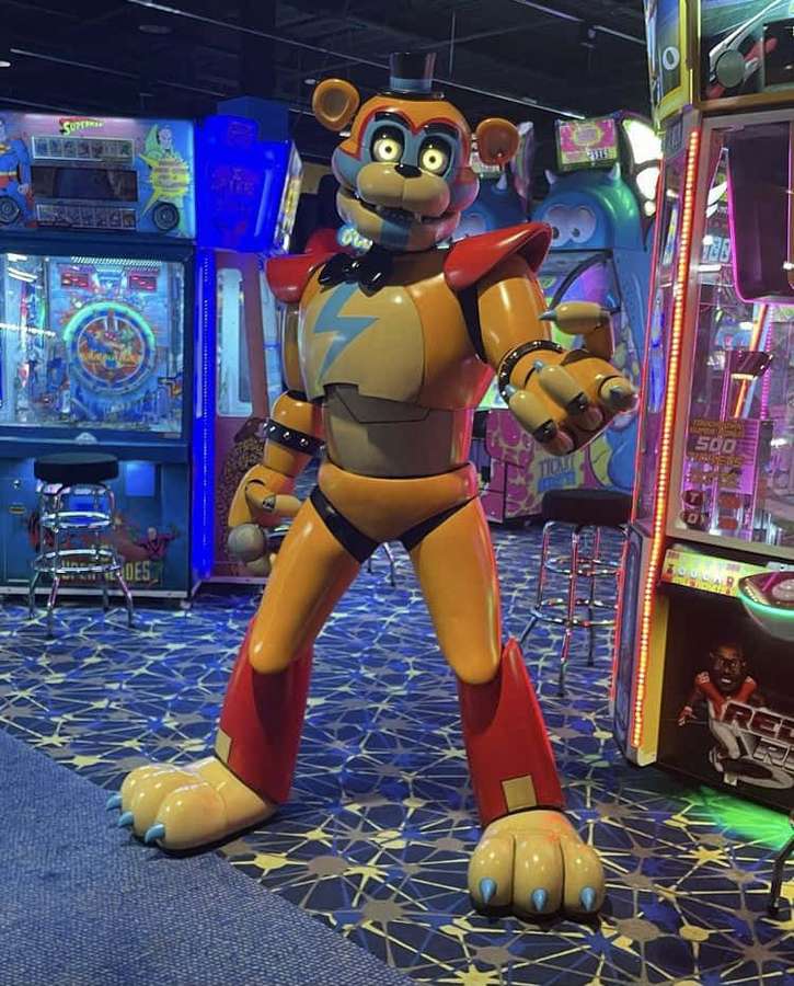 Large animatronic bear in arcade with glowing eyes and red accents. — Fnaf Characters Background