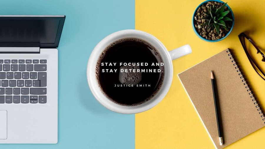 Coffee cup with quote beside laptop notebook and succulent on colorful desk. — Focus Background