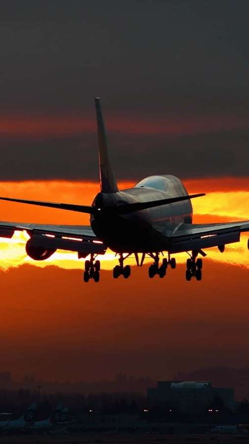 Avión a reacción aterrizando al atardecer con cielo naranja — Fondods de Android Plane Fondos