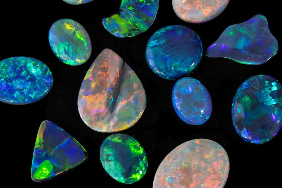 Colección de piedras preciosas de ópalo coloridas con tonos arcoíris sobre fondo negro — Fondods de Opal Fondos