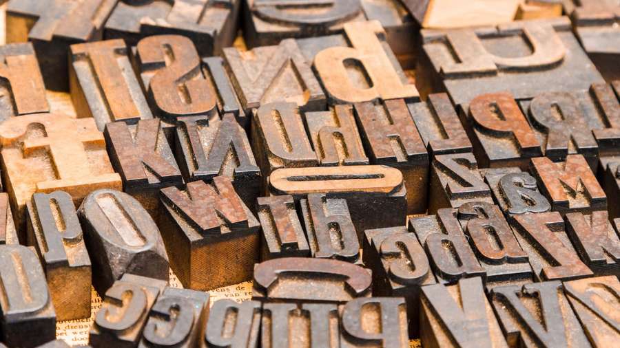 Close-up of vintage wooden letterpress type blocks in disarray. — Font Background
