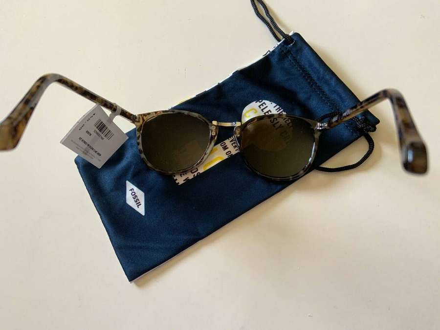 Fossil sunglasses with tortoiseshell frames on a navy blue case. — Fossil Background