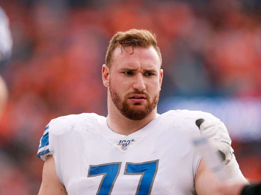 Football player wearing white jersey with blue number 77 on field. — Frank Ragnow Wallpaper