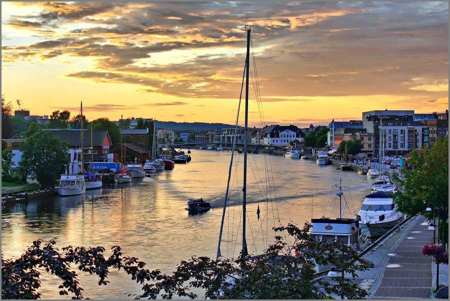 Harbor at sunset with boats docked and buildings along the water. — Fredrikstad Wallpaper