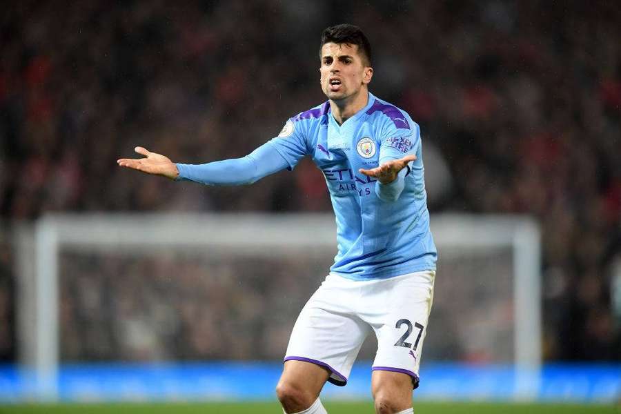Jugador de fútbol de camiseta azul gesticula frustrado en campo lluvioso durante el partido. — Frustrado Fondos de pantalla