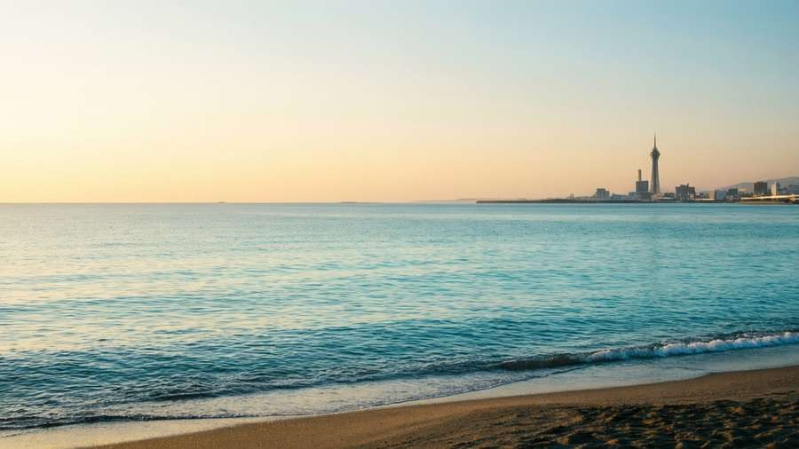 Peaceful sunrise over Momochihama Beach with Fukuoka Tower in distance — Fukuoka Background