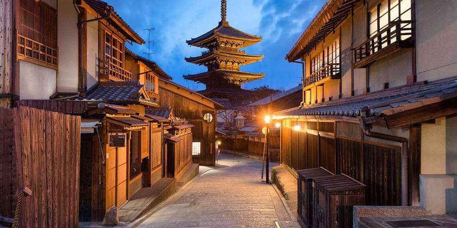 Beco estreito com edifícios de madeira e lanternas que leva a uma pagoda ao entardecer. — Fukuoka Papéis de Parede
