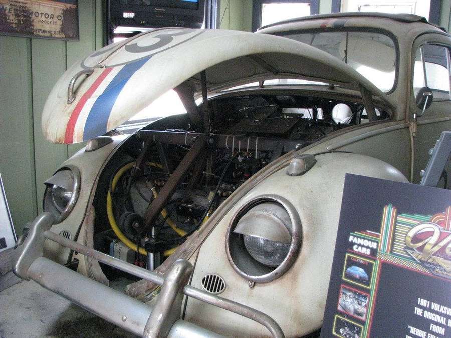 Vintage 1961 Volkswagen Beetle race car with open hood on display in museum garage. — Fully Wallpaper