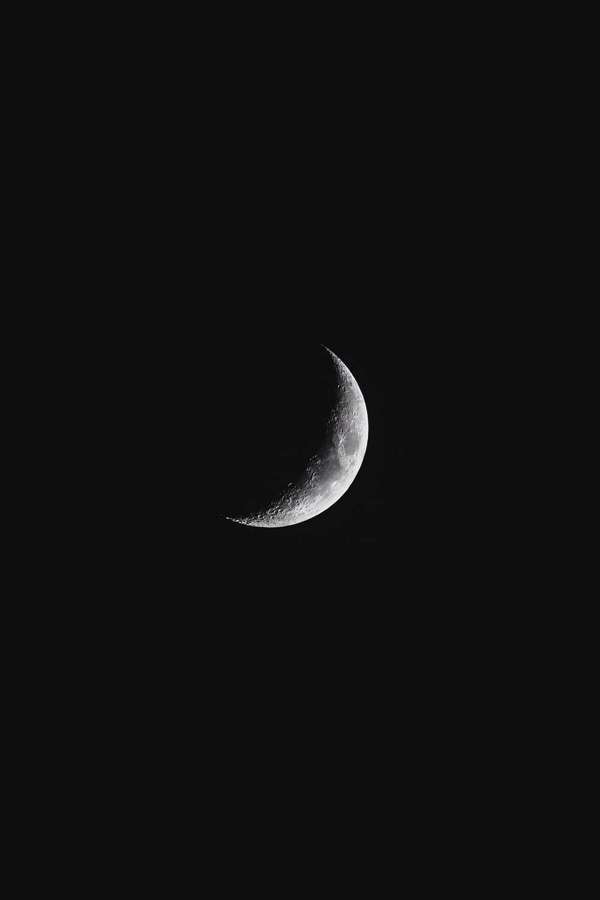 Uma lua crescente com crateras visíveis contra um céu preto — Fundo de lua e estrelas Papéis de Parede