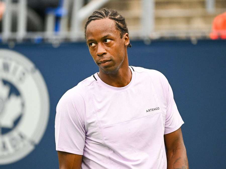 Tennis player in pink shirt looking sideways on court — Gael Monfils Wallpaper