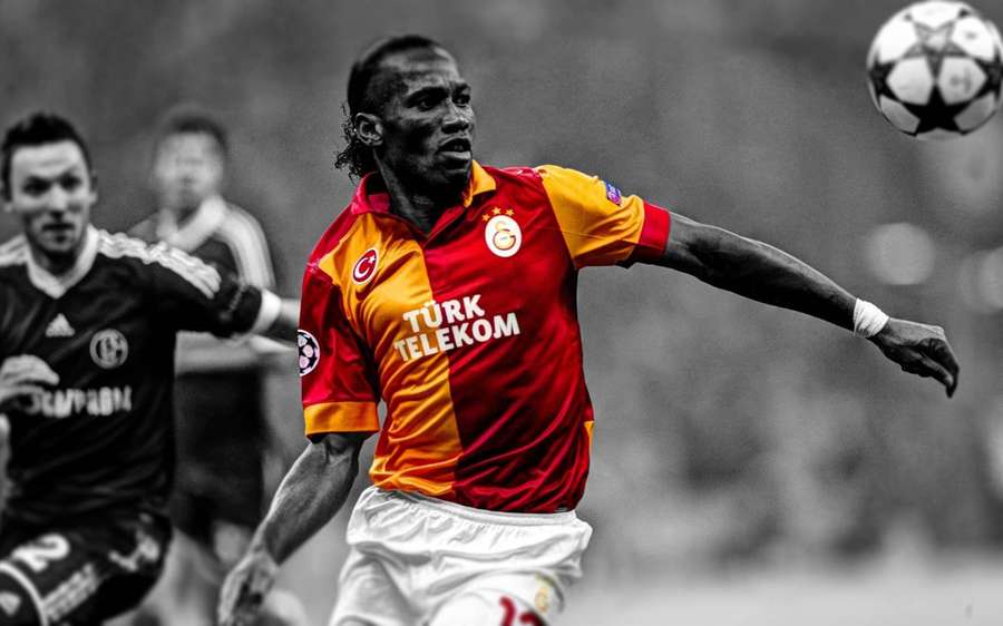 Soccer player in red and yellow jersey heading ball during match. — Galatasaray Background
