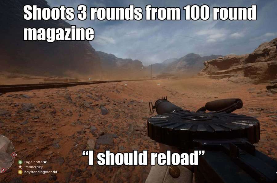 First-person view holding a heavy machine gun in a desert canyon with rocky terrain. — Gaming Memes Wallpaper