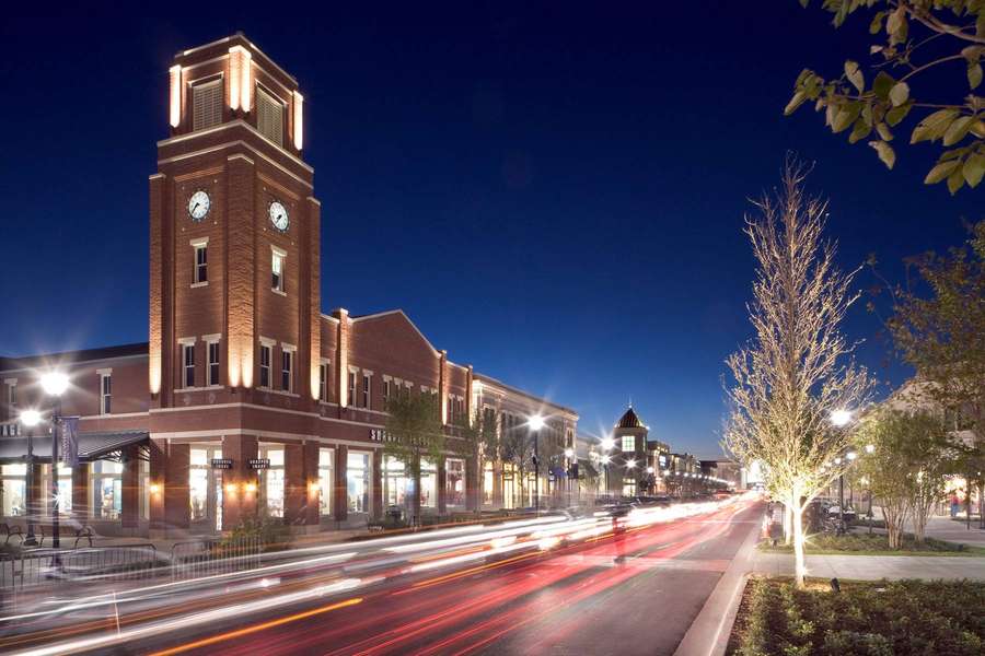 Nighttime urban street with illuminated clock tower and light trails from moving cars. — Garland Wallpaper